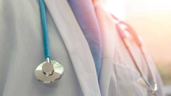 Lékař nebo lékař v uniformě bílé šaty s stetoskop v nemocnici nebo klinice
